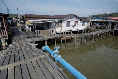 Walkway with blue hookah and huts on stilts in the river