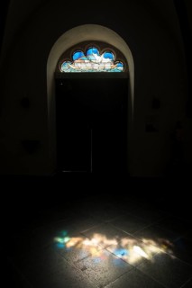 Seitentuer einer Kirche mit kunstvoll verziertem Oberlicht das die Arche Noah mit Taube zeigt