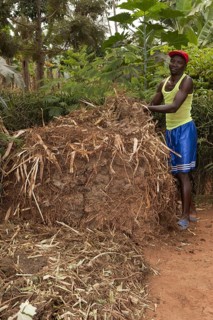 Farmer standing next to compost heap
