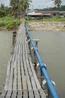 Wooden footbridge with blue hookah over the river