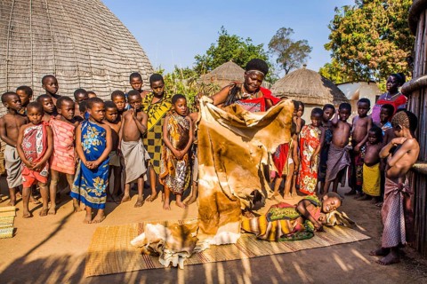 Children watch with interest at traditional customs in real African village