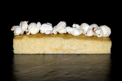 A piece of fried corn polenta with pop corn