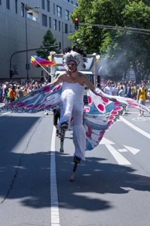 Transvestite costumed as a butterfly on stilts at the CSD parade
