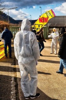 People in protective suits and with gas masks demonstrate against the storage of nuclear waste