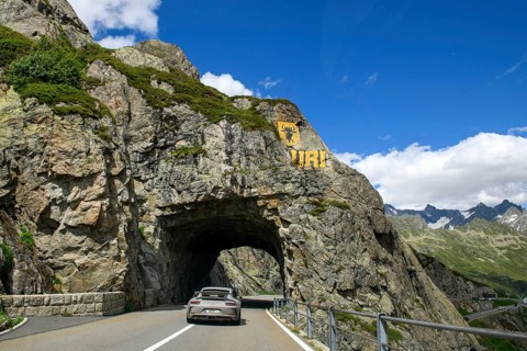 Supercar sports car Porsche GT3 driving tunnel carved in rock