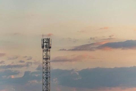 Telecom antenna in countryside in summer at sunset. Alsace