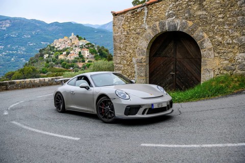 Re-enactment of classic photo of Porsche 911 at historic section of Monte Carlo Rally 1965 with modern supercar sports car Porsche GT3