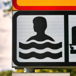 Sign Bathing Place by the Sea with Pictogram Swimmer