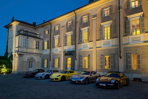 Night shot of five Porsche sports cars in representative courtyard of 18th century Hotel Villa Matilde during blue hour
