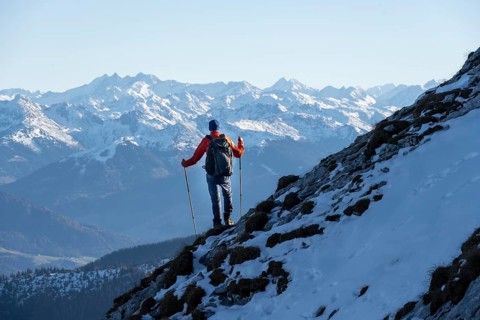 Mountaineers on the rocky summit ridge with the first snow in autumn