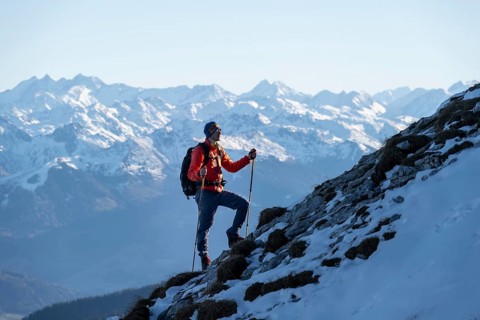 Mountaineers on the rocky summit ridge with the first snow in autumn