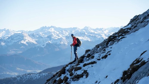 Mountaineers on the rocky summit ridge with the first snow in autumn