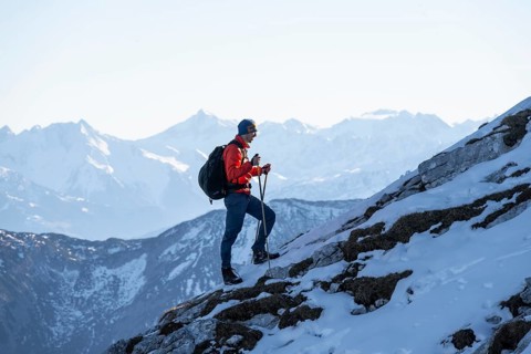 Mountaineers on the rocky summit ridge with the first snow in autumn