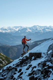 Mountaineers on the rocky summit ridge with the first snow in autumn