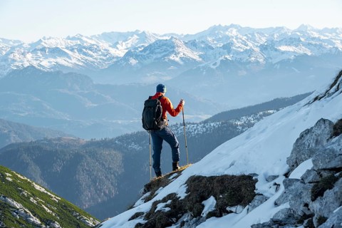 Mountaineers on the rocky summit ridge with the first snow in autumn
