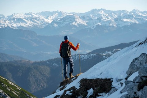 Mountaineers on the rocky summit ridge with the first snow in autumn