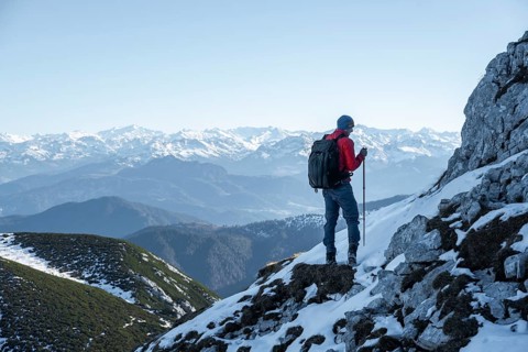 Mountaineers on the rocky summit ridge with the first snow in autumn