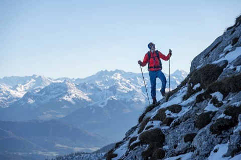 Mountaineers on the rocky summit ridge with the first snow in autumn