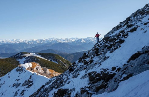 Mountaineers on the rocky summit ridge with the first snow in autumn