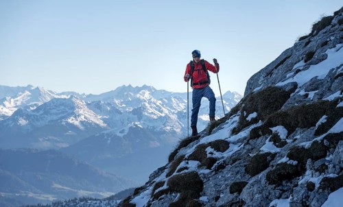 Mountaineers on the rocky summit ridge with the first snow in autumn
