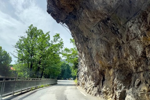 Far overhanging rock face over narrow road in gorge Clue de St-Auban with protection against falling rocks