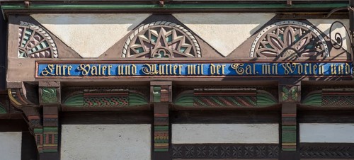 Coloured carving and saying 'Honour father and mother with deed