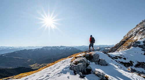 Climbers on the rocky summit ridge with first snow in autumn
