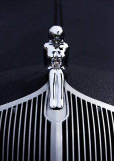 A naked woman as a radiator mascot on a vintage car
