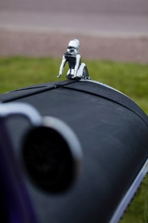 A naked woman as a radiator mascot on a vintage car