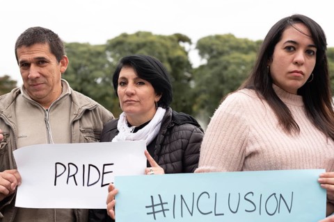 A group of people holding inclusion and pride signs as a protest. LGBT Concept
