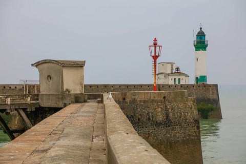 Top of the quay wall with lighthouse in the harbour of the coastal town of Le Treport at the mouth of the Bresle on the English Channel