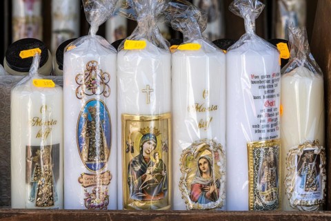 Candles with images of Mary and the saints in front of a devotional shop at Kapellplatz