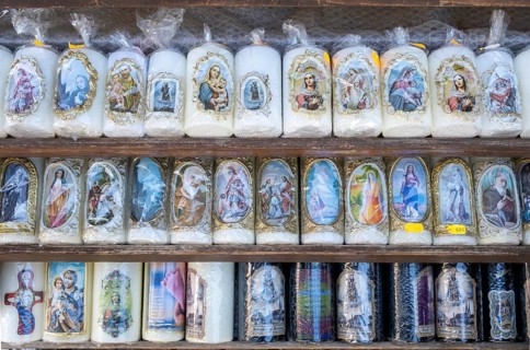 Candles with images of Mary and the saints in front of a devotional shop at Kapellplatz