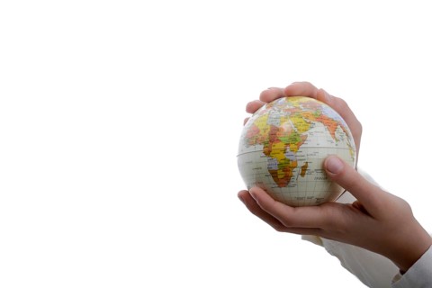 Child holding a small globe in hand on white background