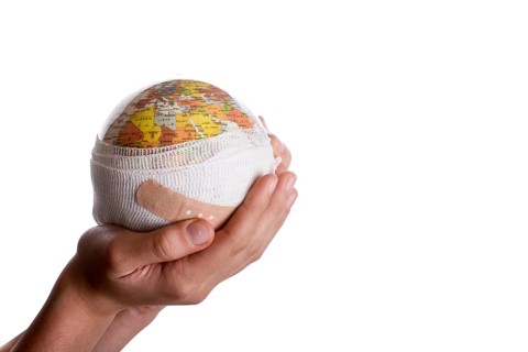 Child holding a globe with plaster in his hand on a white background