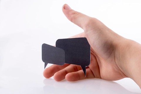 Hand holding dialogue boxes on a white background