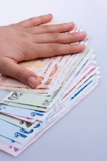 Hand holding Turksh Lira banknotes on white background