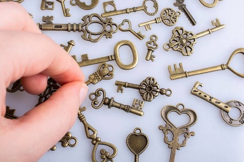 Hand and retro style metal keys on a white background