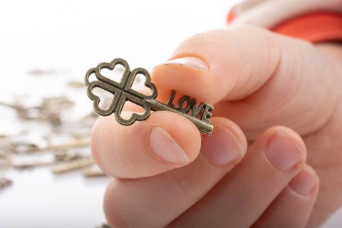 Hand and retro style metal keys on a white background