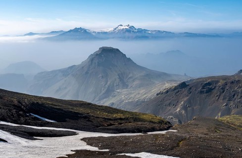 View of mountain peaks between fog