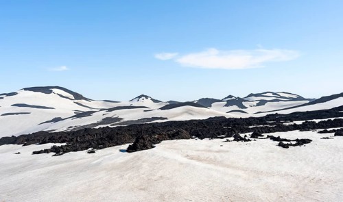 Barren hilly volcanic landscape of snow and volcanic rock