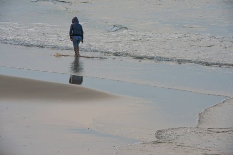 Fisherman walking along the beach