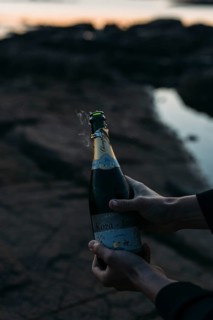 Opening a bottle of champagne on the beach