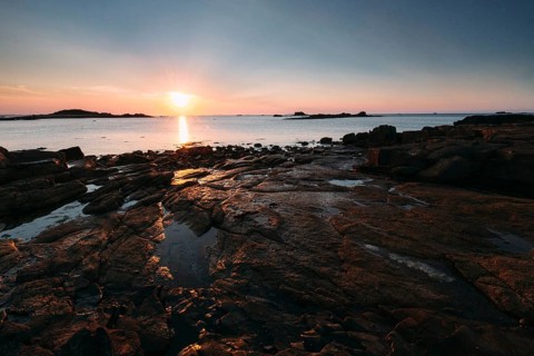 Rocks on the beach of Port Blanc in the evening light