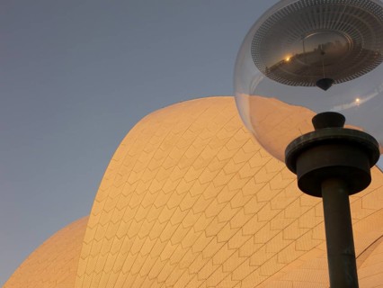 A lamp in front of the Sydney Opera House reflects the city skyline, Australia -