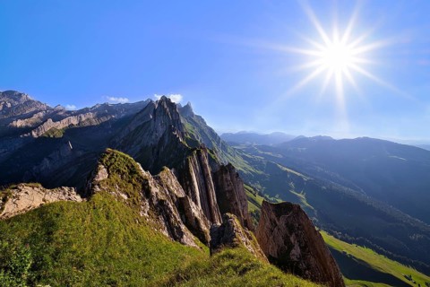 View of the Alpstein mountains in Appenzell, direct backlight with sun star in a cloudless sky