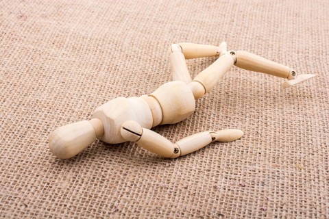 Wooden dolls of a man posing on canvas,