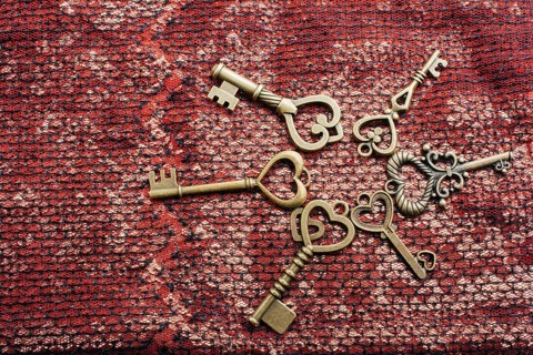 Heart shaped retro metal keys on bright background,