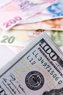 American dollar banknotes and Turksh Lira banknotes side by side on white background,
