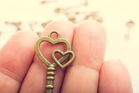 Hand and retro style metal keys on a white background,